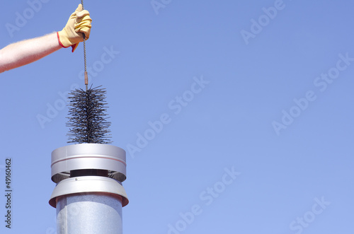 Billede på lærred Cleaning chimney with sweeper sky background