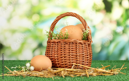 Eggs in basket on grass on natural background