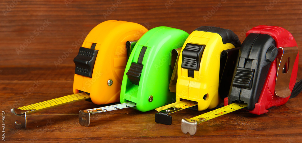 Tape measure on wooden background Tape measure on wooden background
