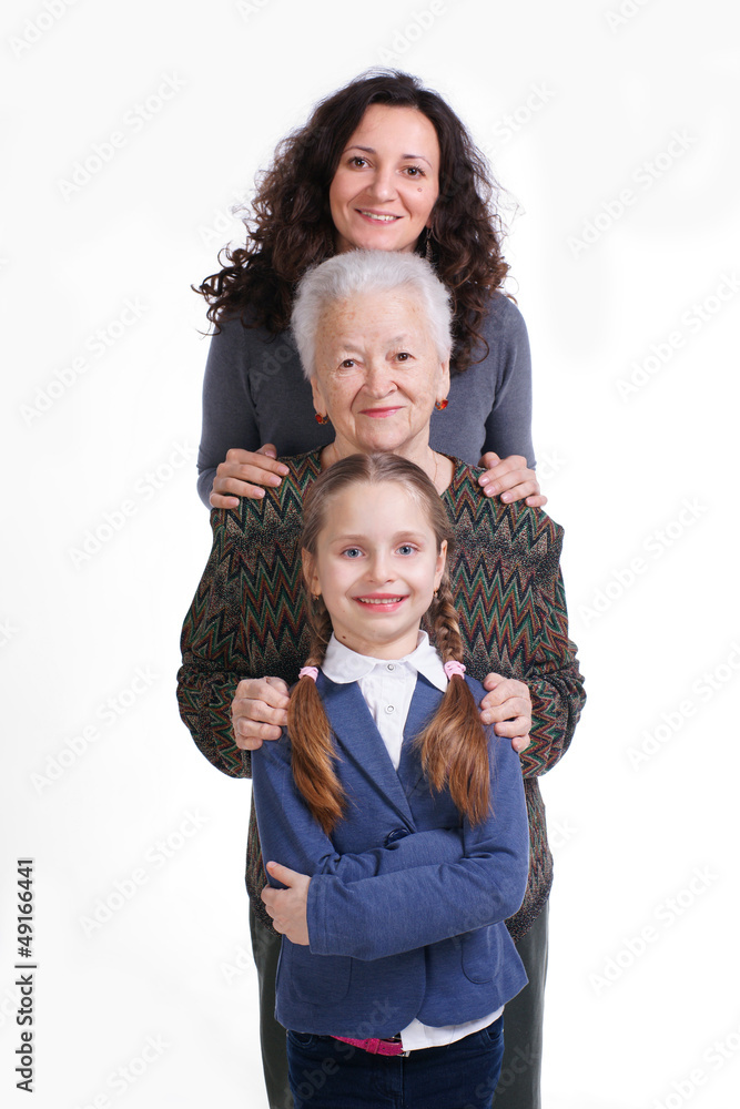 Row of little girl, grandmother, mother looking at camera in lin Row of little girl, grandmother, mother looking at camera in lin