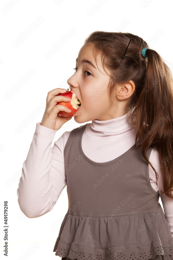 pretty little girl in a dress eats a tasty apple on white pretty little girl in a dress eats a tasty apple on white