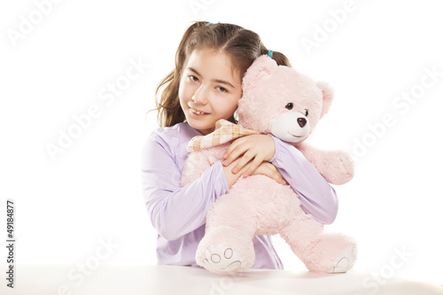 a nice little girl holding a pink Teddy bear in her arms