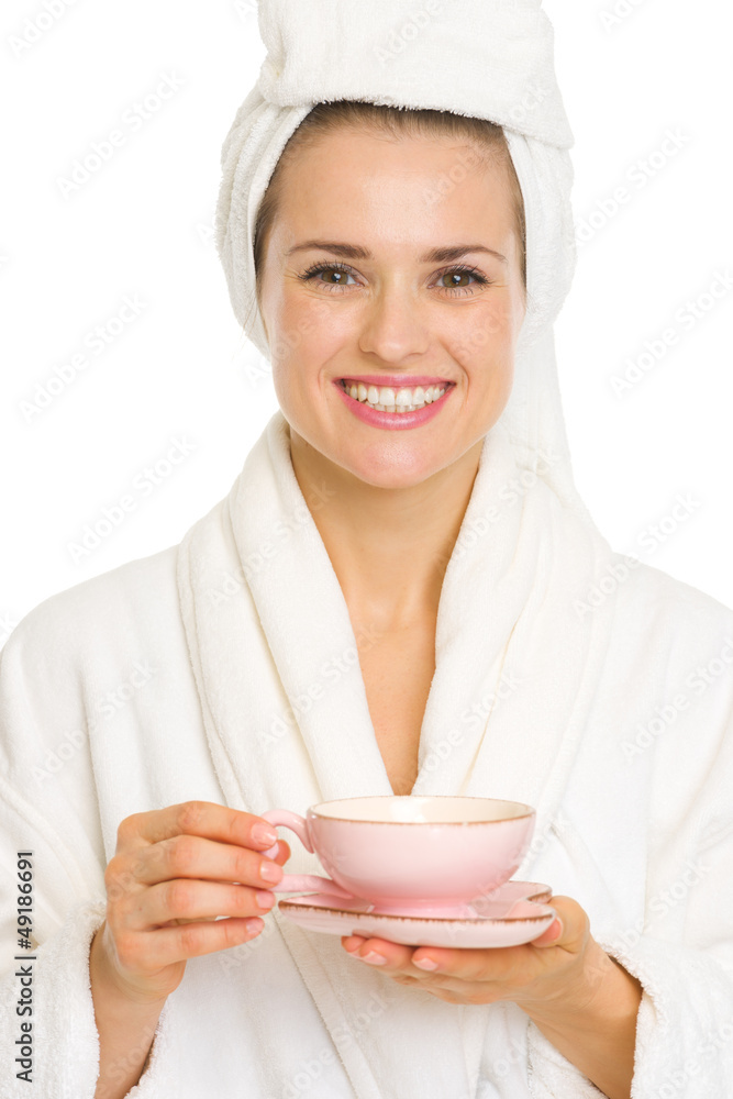 Happy young woman in bathrobe holding cup of tea Happy young woman in bathrobe holding cup of tea