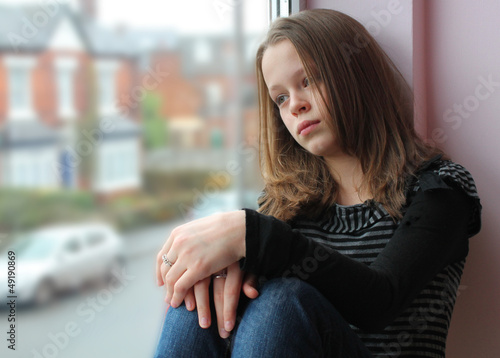 Stunning portrait of a young girl gazing out of the window