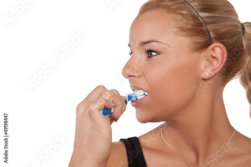 Beautiful young healthy woman brushing her teeth