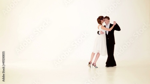 passionate, young couple showing dance moves on white background