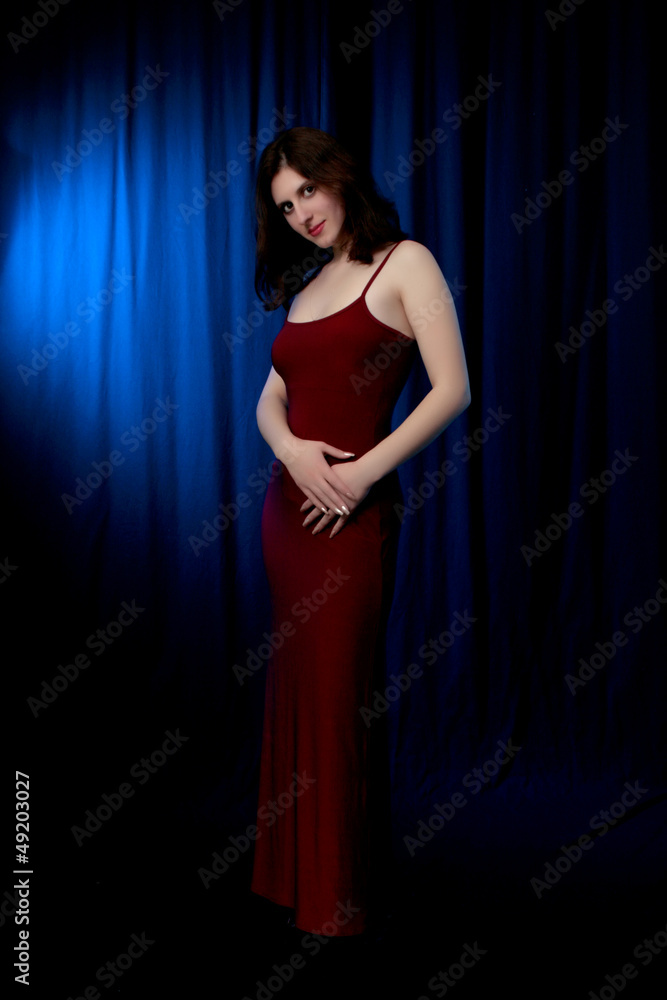 brunette in a red dress on a black background brunette in a red dress on a black background