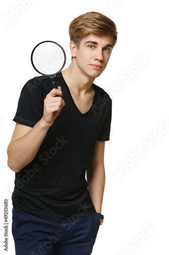 Young man holding magnifiying glass, over white background