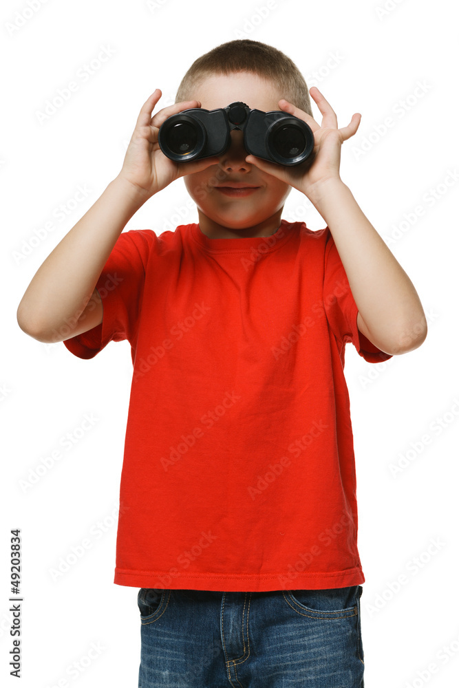 Front view of six years boy looking away through binoculars Front view of six years boy looking away through binoculars