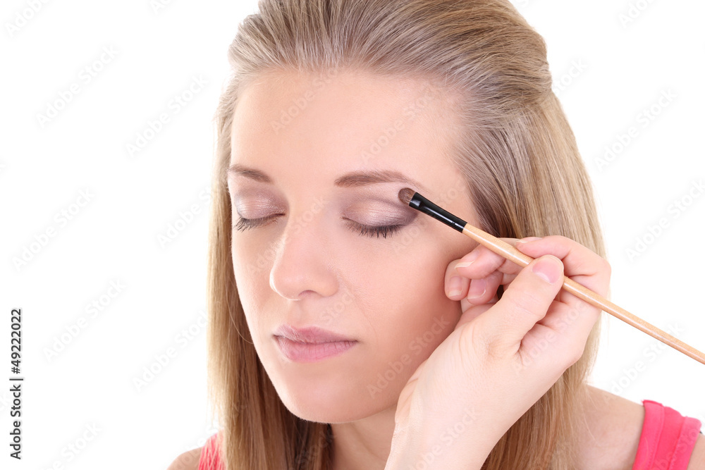 young blonde with make-up brush over white