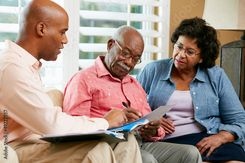 Billede på lærred Financial Advisor Talking To Senior Couple At Home