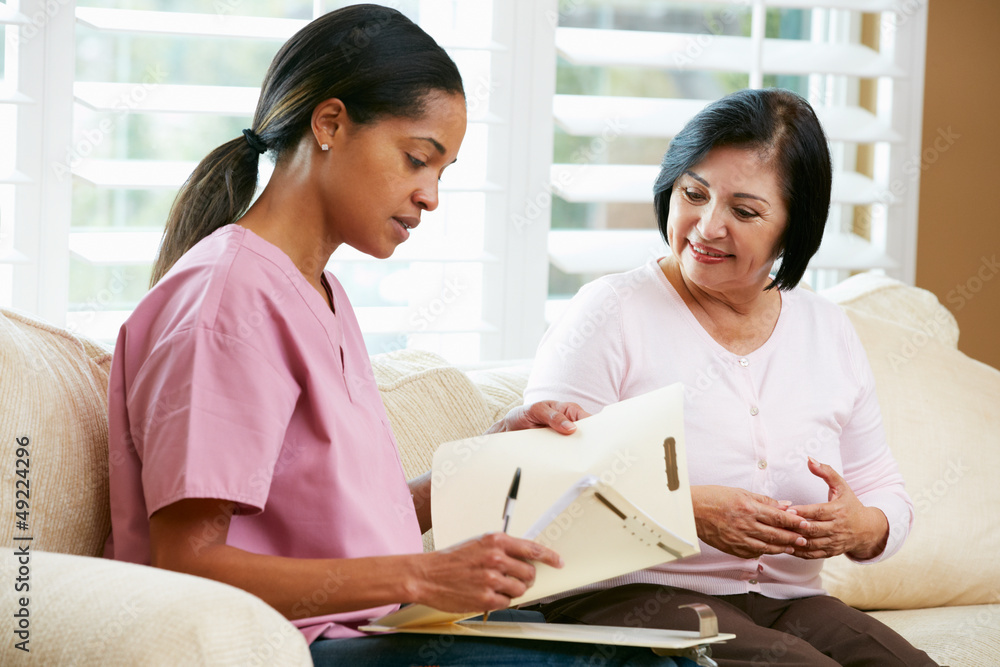 Nurse Discussing Records With Senior Female Patient at Home Nurse Discussing Records With Senior Female Patient at Home