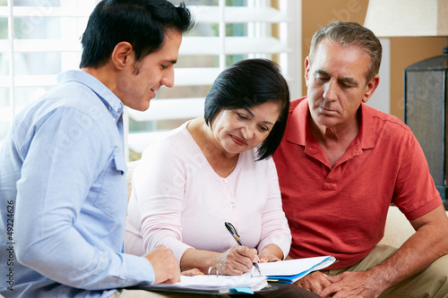 Financial Advisor Talking To Senior Couple At Home photo