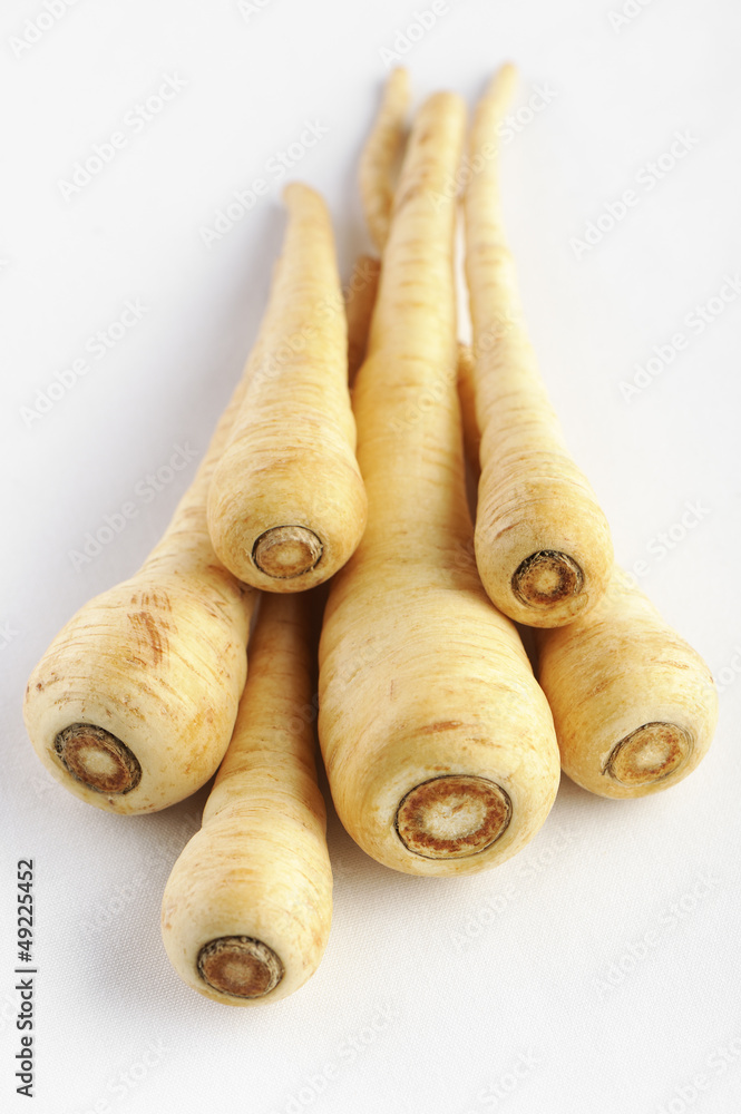 Parsnip on a white background, selective focus. Parsnip on a white background, selective focus.