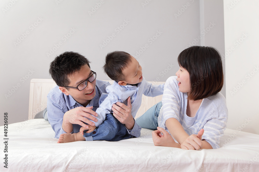 happy family playing on white bed