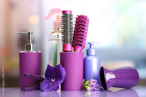 Fototapeta Naklejka Na Ścianę i Meble -  Hair brushes, hairdryer, straighteners and cosmetic bottles in