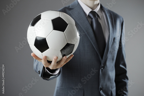 Elegant businessman holding a soccer ball © stokkete