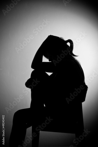 sad woman sitting alone in a empty room - black and white