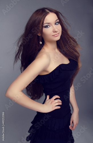 Elegant woman with long straight hair, lady in black dress posin