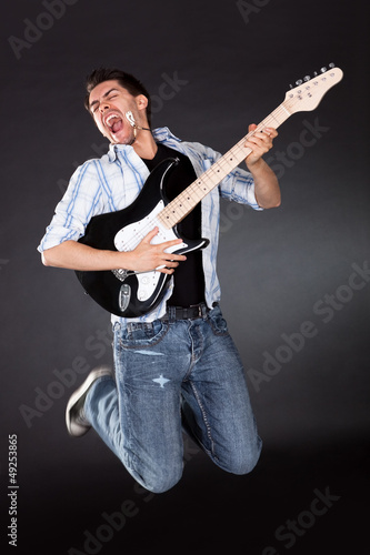 Musician jumping with his guitar