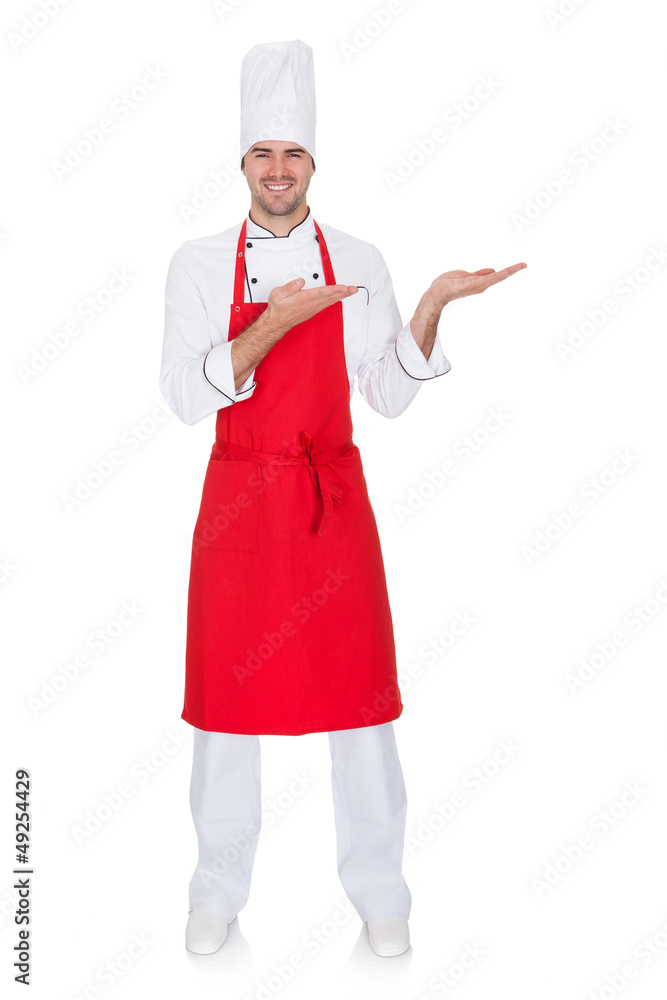 Portrait of cheerful chef in uniform presenting Portrait of cheerful chef in uniform presenting