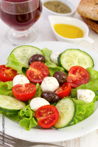 salad on the plate with oil and glass of wine