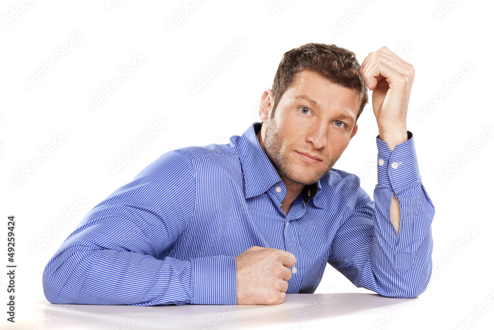 sad, serious man in a blue shirt on white desk sad, serious man in a blue shirt on white desk