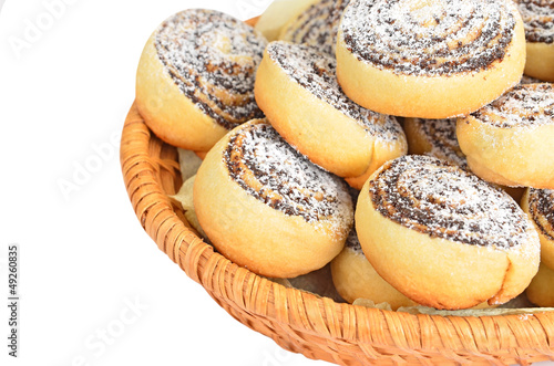 Cookie roll with poppy in a wattled basket, isolated on white