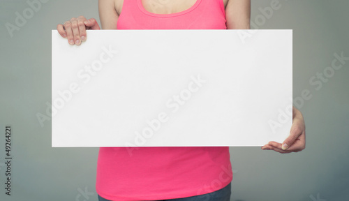 Woman holds an empty white board in both hands