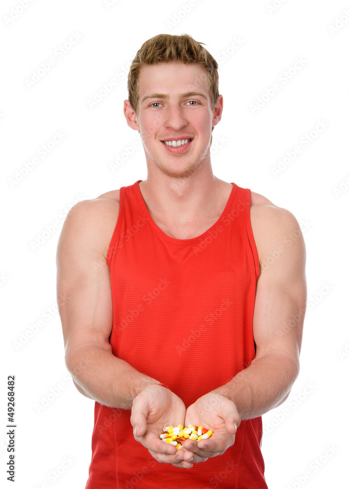smiling athletic man holding some pills smiling athletic man holding some pills