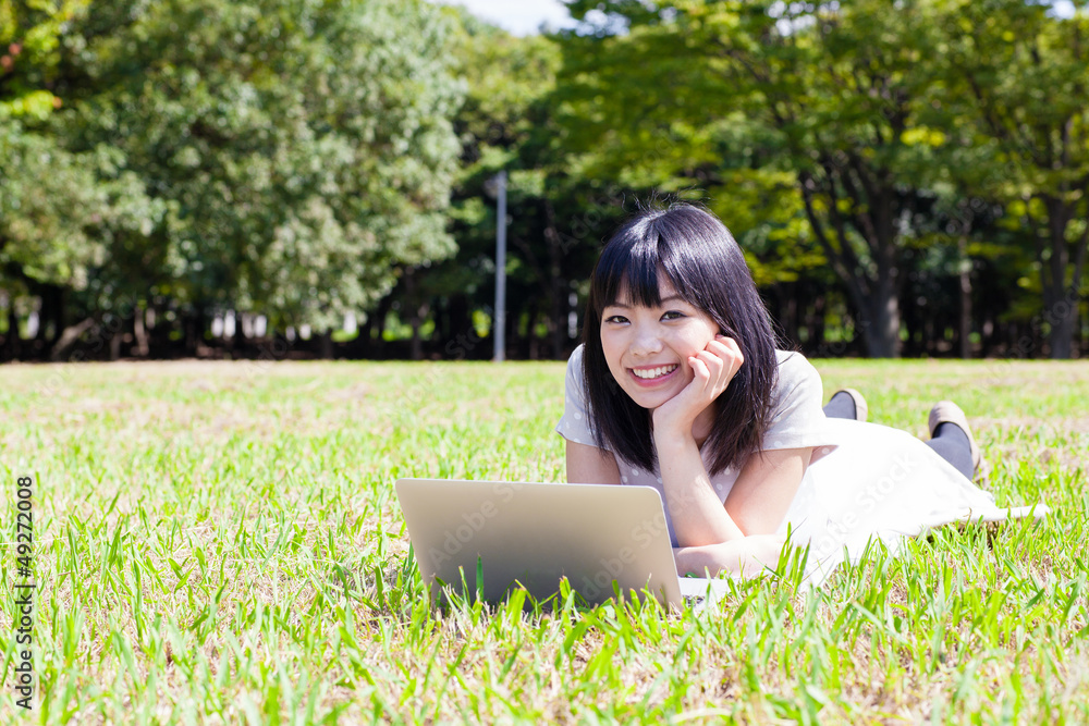 atractive asian woman using laptop in the park atractive asian woman using laptop in the park