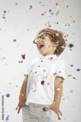 Smiling child with rimmed glasses and confetti