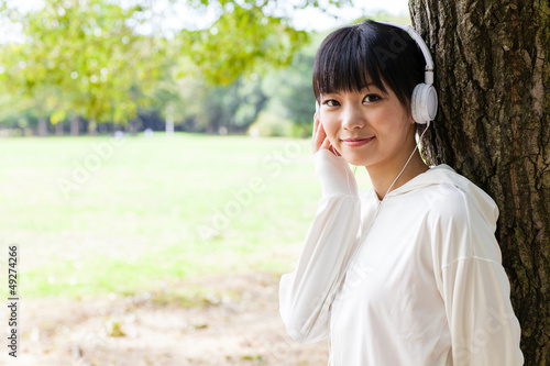 attractive asian woman using laptop in the park