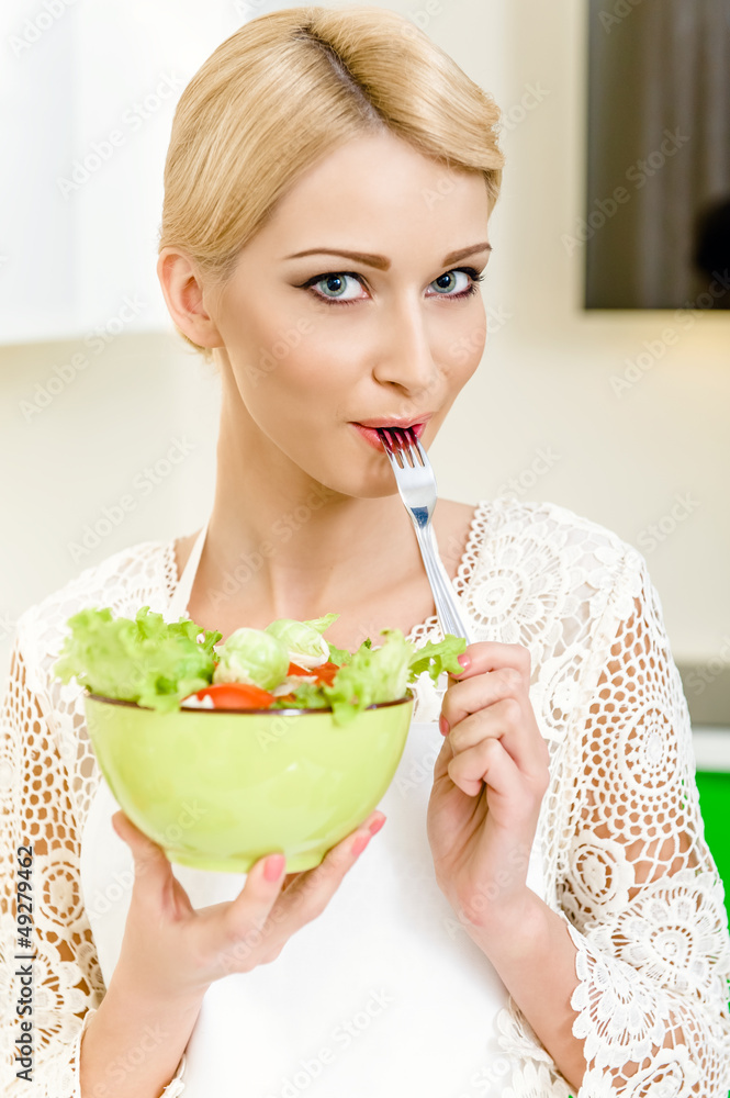 Portrait of a beautiful young woman eating vegetable salad Portrait of a beautiful young woman eating vegetable salad