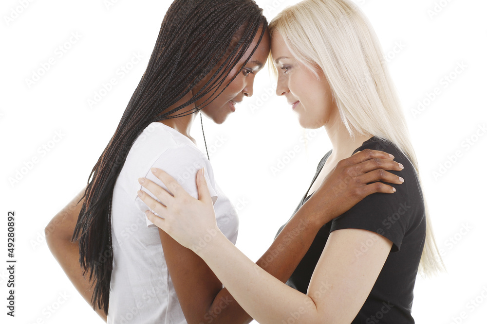 Afrikanerin und Europäerin zusammen mit Köpfen aneinander Afrikanerin und Europäerin zusammen mit Köpfen aneinander