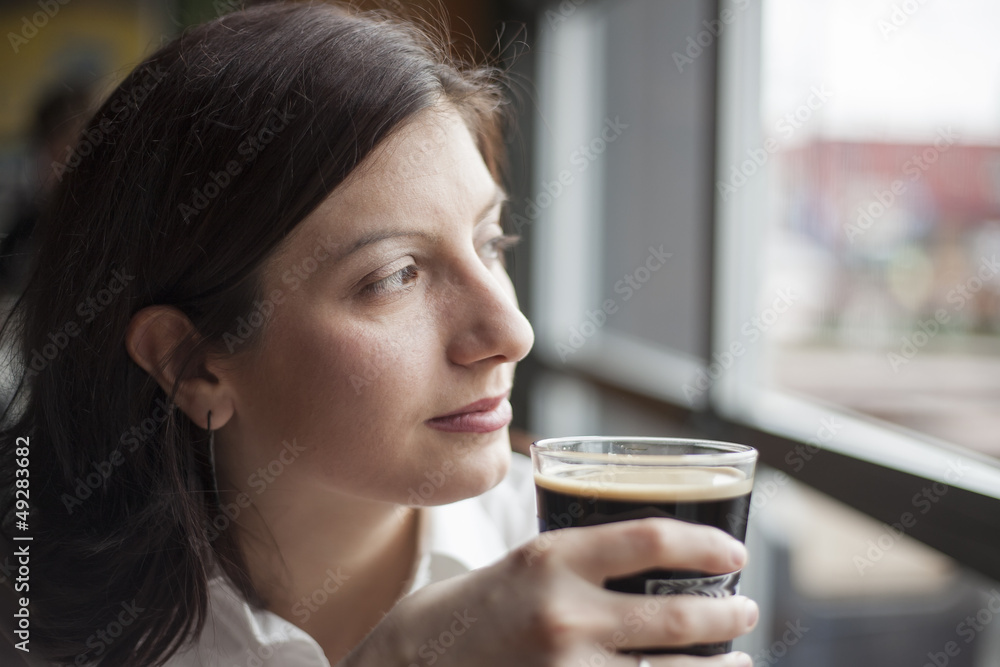 Young Woman with Beautiful Brown Eyes Drinking a Pint of Stout Young Woman with Beautiful Brown Eyes Drinking a Pint of Stout