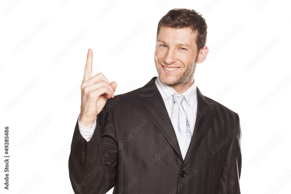 Young Businessman showing something by his index finger Young Businessman showing something by his index finger