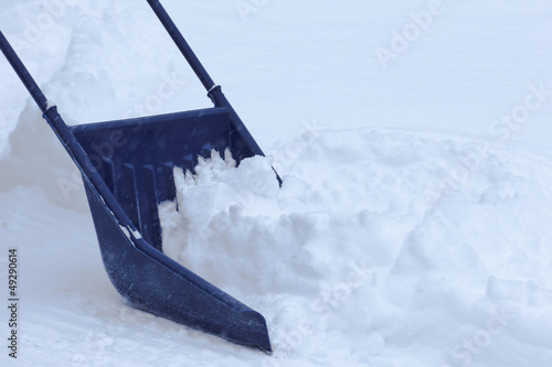 Manual snow removal with snow scoop after blizzard