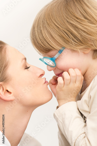Young mother with her son playing and kissing each other