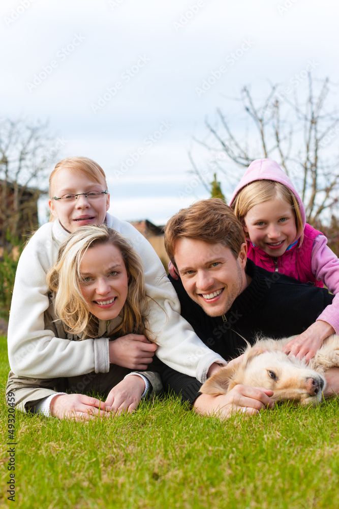 Fototapeta premium Eine Familie sitzt zusammen auf einer Wiese