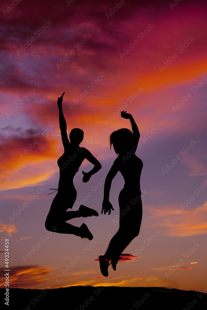 tow women fitness jumping sunset