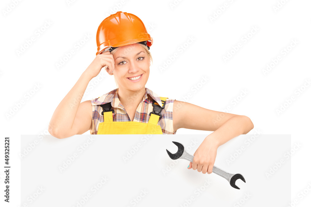 A smiling female worker holding a wrench and standing behind pan A smiling female worker holding a wrench and standing behind pan