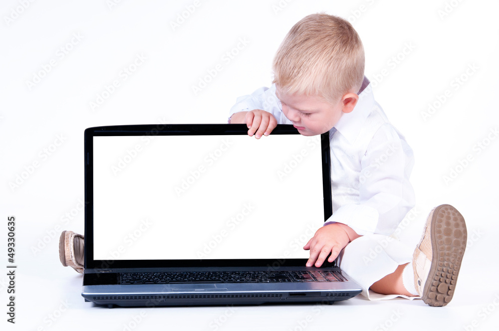 Little business boy in solid white suit sitting at notebook on Little business boy in solid white suit sitting at notebook on