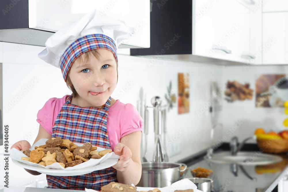 Cute little girl holding plate with cookies Cute little girl holding plate with cookies