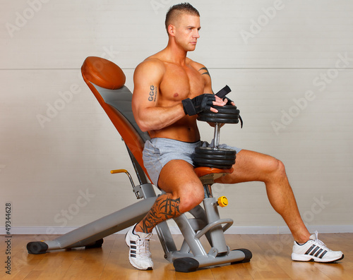 Handsome man with muscles lift a dumbbell