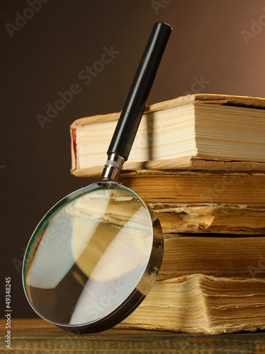 Magnifying glass and books on table