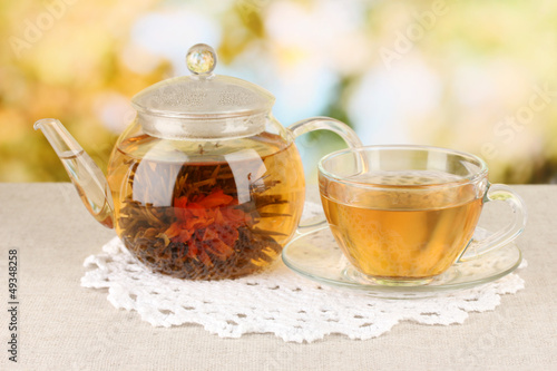 Exotic green tea with flowers in glass teapot