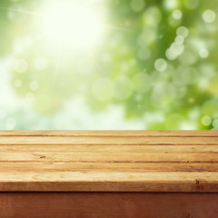 Empty wooden deck table with foliage bokeh background