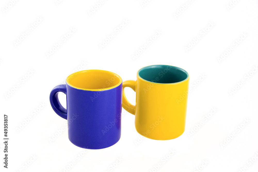 two cups near each other - yellow and blue two cups near each other - yellow and blue