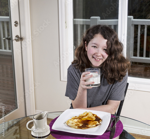 Young Girl Drinking Milk with her Breakfast Meal
